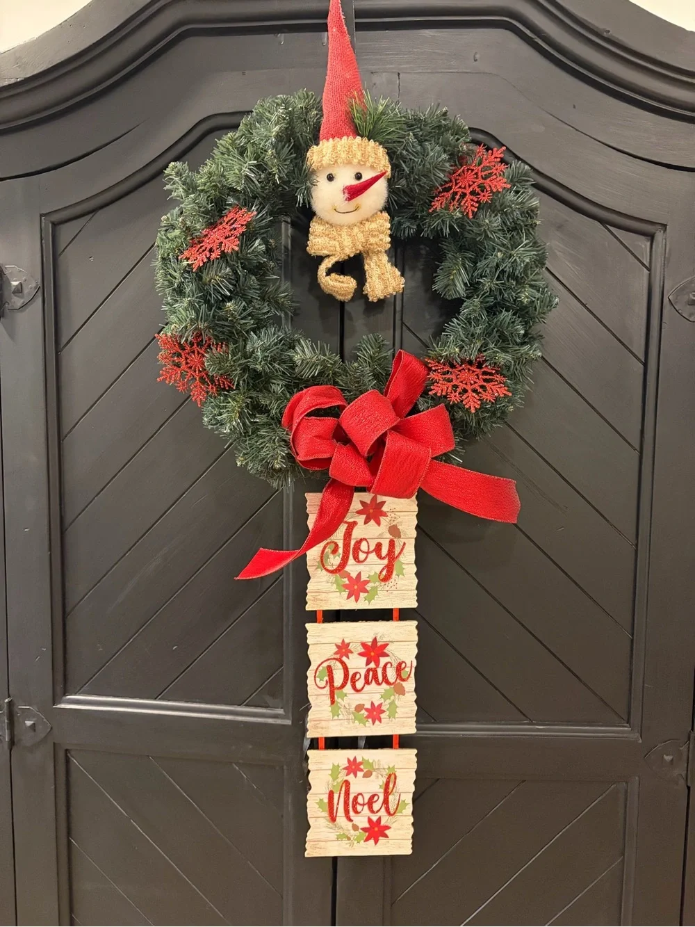 Festive Green Holiday Wreath with Red Accents and Hanging Signs
